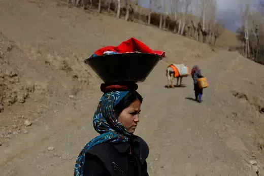 A girl carries her belongings in a container on her head in Bamiyan, Afghanistan, March 2, 2023.