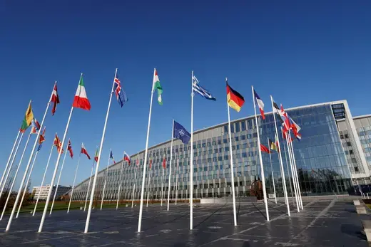 A circle of flags as viewed outside of NATO's headquarters.