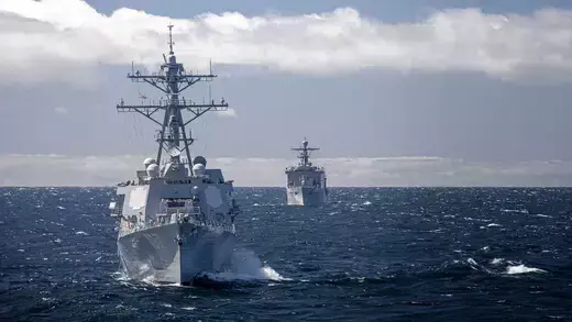 The Arleigh Burke-class guided-missile destroyer USS Gravely, steams ahead of the Whidbey Island-class amphibious dock landing ship USS Gunston Hall during a maneuvering exercise. 