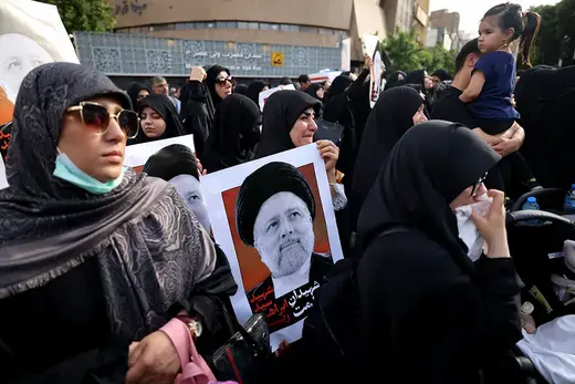 A group of Iranian women gather outside in mourning over the death of President Ebrahim Raisi carrying images of the deceased president.