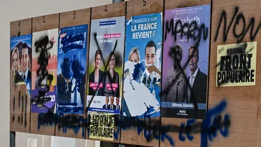 "Macron non" is written across vandalized posters in France.