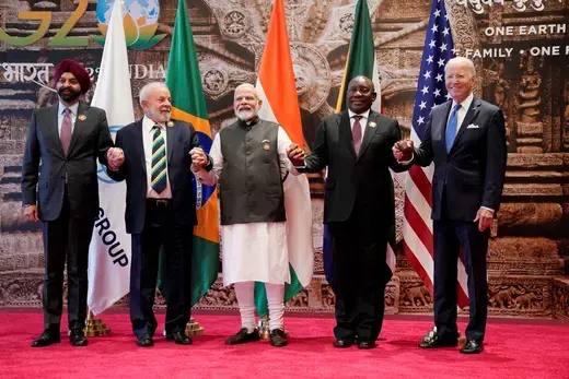 World Bank President Ajay Banga, Brazilian President Luiz Inacio Lula da Silva, Indian Prime Minister Narendra Modi, South African President Cyril Ramaphosa, and U.S. President Joe Biden pose in front of national flags and join hands at the summit in New Delhi, India on September 9, 2023. 