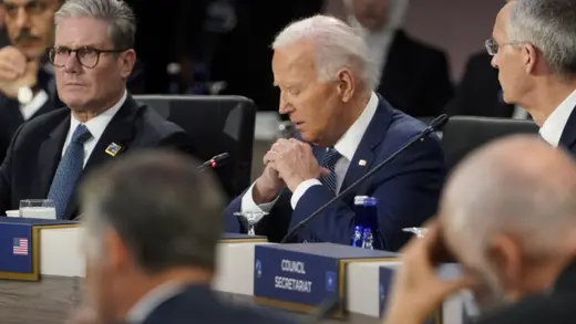 U.S. President Joe Biden looks down as he sits next to British Prime Minister Keir Starmer at the NATO Summit in Washington, in July 2024.