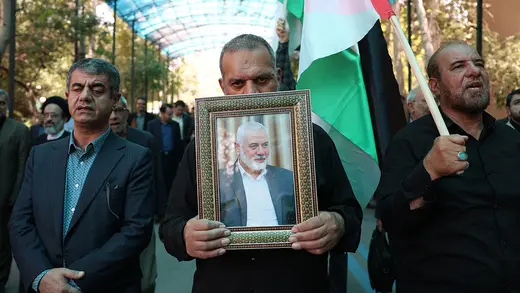 People hold up the Palestinian flag and a portrait of assassinated Hamas political leader Ismail Haniyeh in Tehran, Iran.