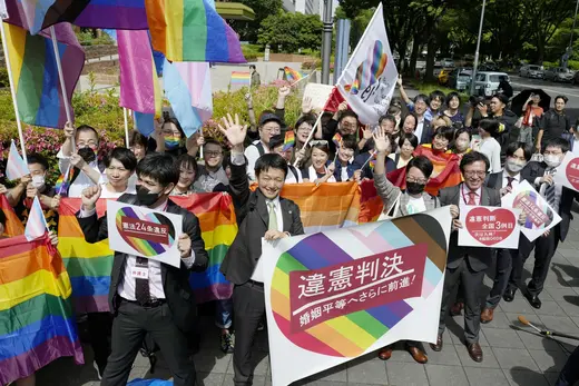 People including plaintiffs' lawyers hold banners and flags, after the lower court ruled that not allowing same-sex marriage was unconstitutional, outside Nagoya district court, in Nagoya, central Japan