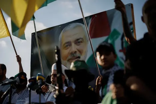 Demonstrators hold flags and weapons next to an image of late Hamas leader Ismail Haniyeh, during a protest to condemn his assassination in Iran, in Sidon, Lebanon, on July 31, 2024. Alkis Konstantinidis/Reuters