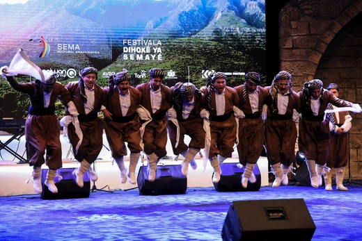 Kurdish men in traditional folklore costumes perform during the Duhok Dance Festival in Duhok Province, Iraq.