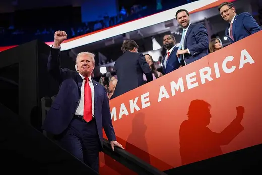 Donald Trump raises a closed fist at the 2024 Republican convention, next to vice-presidential nominee JD Vance and House Speaker Mike Johnson.