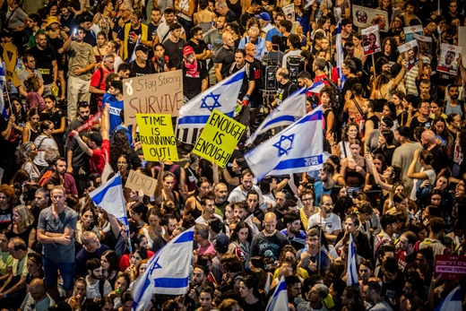 Protestors hold up placards and wave the Israeli flag during the demonstration in Tel Aviv, Israel, on September 1, 2024. Eyal Warshavsky/SOPA Images/LightRocket/Getty Images