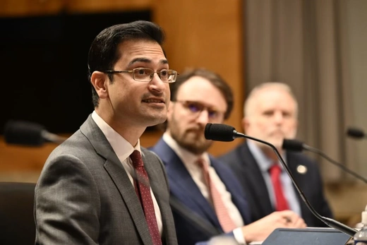 Rush Doshi speaks into the microphone during his testimony.