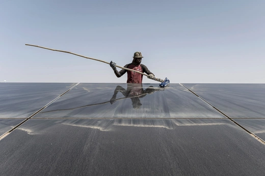 A worker cleans the solar panels at the 15MW Sheikh Zayed Solar Power Plant in Nouakchott, on March 21, 2023.