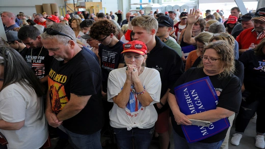 Supporters of Republican presidential nominee and former U.S. President Donald Trump pray during the invocation on the day Trump makes a campaign stop at manufacturer FALK Production in Walker, Michigan, U.S. September 27, 2024.