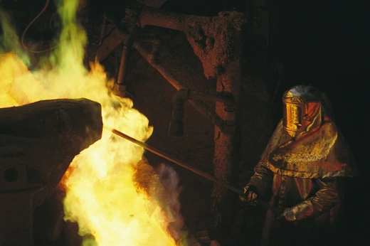 Man in protective gear tends a smelter at Magma Metals Company, near San Manuel, Arizona, USA; Arizona, United States of America