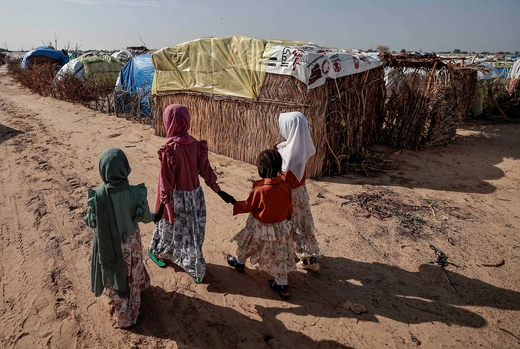 Sudanese girls who fled the conflict in Sudan's Darfur region, walk beside makeshift shelters holding each other's hands in Adre, Chad July 29, 2023.