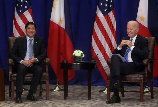 Philippine President Marcos wears a black suit while he sits with U.S. President Biden, who wears a black suit.