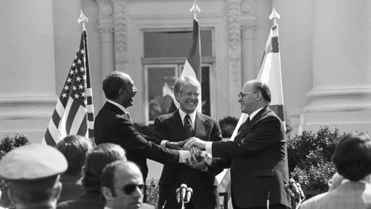 Egyptian President Anwar Sadat, U.S. President Jimmy Carter, and Israeli Prime Minister Menachem Begin celebrate the signing of the Camp David Accords between Egypt and Israel.