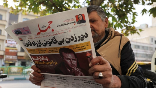 An Iranian man reads a newspaper with a picture of Syrian President Bashar al-Assad in Tehran, Iran, December 8, 2024.