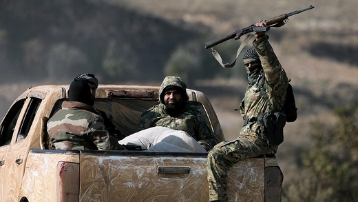 Anti-government fighters ride in the back of a truck in Suran, between Aleppo and Hama, Syria, on December 3, 2024.