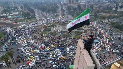 A man waves the independence-era Syrian flag over Damascus’ central Umayyad Square on December 11, 2024. 