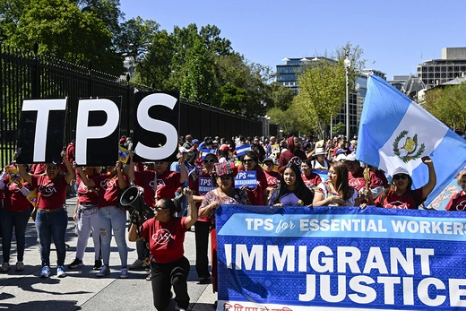 People demand TPS for essential workers during a march in front of the White House in 2023.