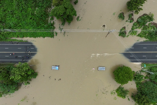 A bridge is submerged by a flooded river in Toa Baja, Puerto Rico, in the wake of Hurricane Ernesto.