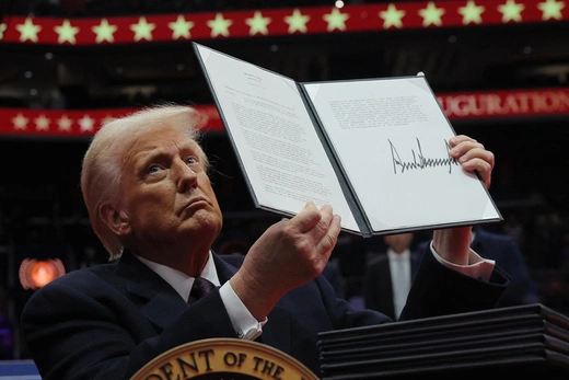 President Donald Trump presents an executive order during his inaugural parade inside the Capital One Arena in Washington, DC.