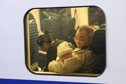 A baby looks out a window of the train during the Spring festival travel rush ahead of the Lunar New Year, at Shanghai Hongqiao railway station in Shanghai, China, January 24, 2025. 