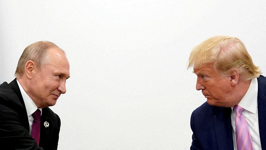 U.S. President Donald Trump and Russian President Vladimir Putin backgrounded by a white wall while meeting in Osaka, Japan.