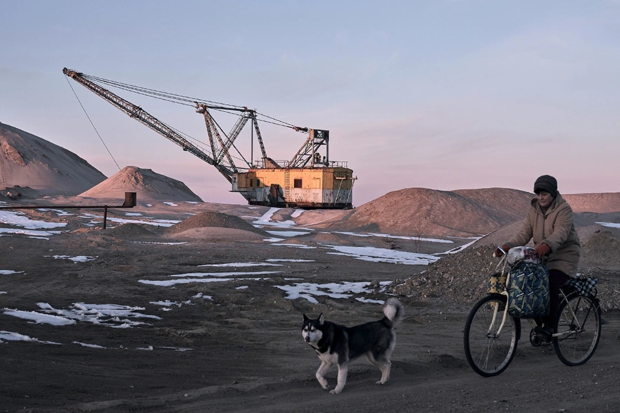 A woman cycles past with her dog as Drag-line excavator mines rare earth materials in Ukraine on February 25, 2025. Kostiantyn Liberov/Libkos/Getty Images