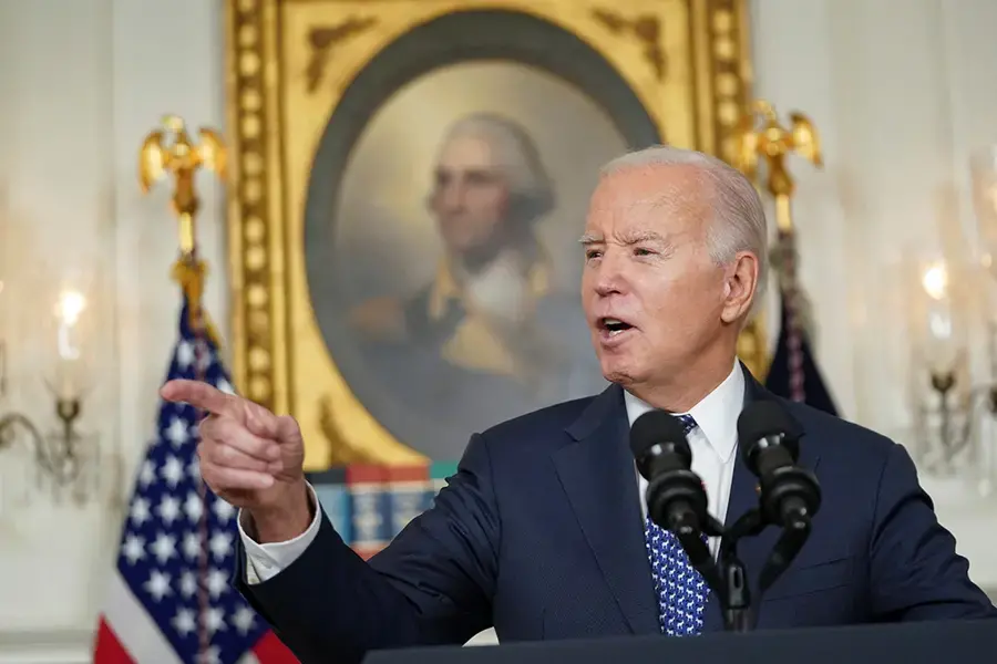 Suited Joe Biden points sternly in a White House office.