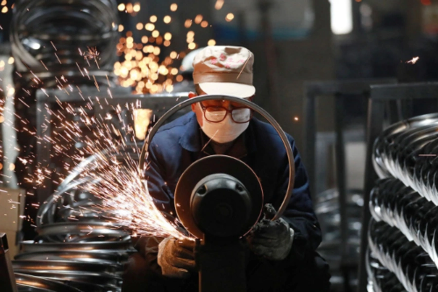 A worker polishes steel bicycle rims at a factory that produces and exports bicycle parts, in Hangzhou, China. AFP/Getty Images