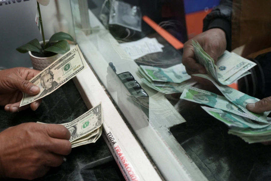 A person exchanges U.S. dollars for Colombian pesos at a currency exchange house in Bogota, Colombia, on June 10. Nathalia Angarita/Reuters