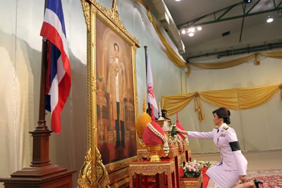 Thailand's PM Yingluck Shinawatra pays respect in front of a portrait of Thai King Bhumibol Adulyadej in Bangkok.