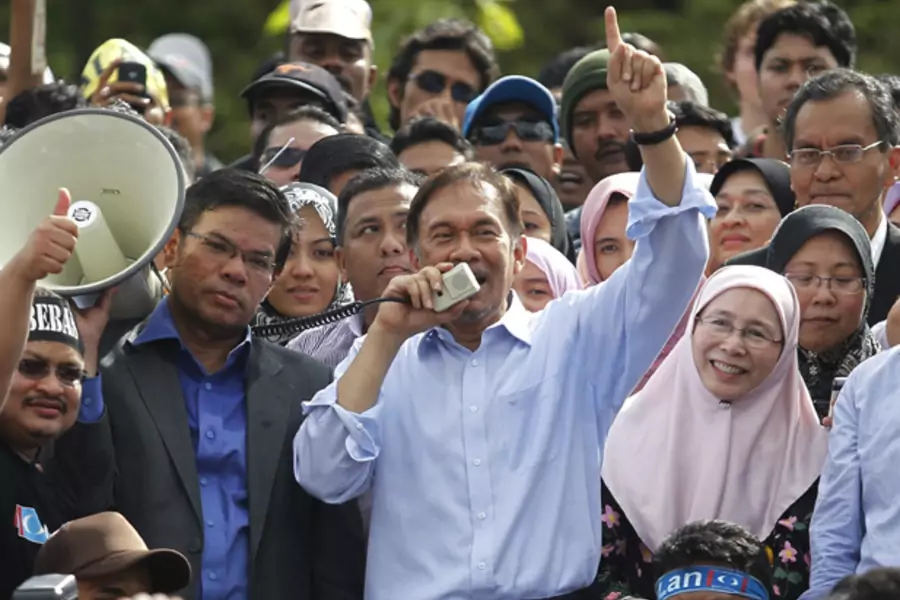 Malaysia's opposition leader Anwar Ibrahim (C) talks to his supporters while flanked by his wife Wan Azizah Wan Ismail after the verdict of his sodomy trial was announced in Kuala Lumpur January 9, 2012.