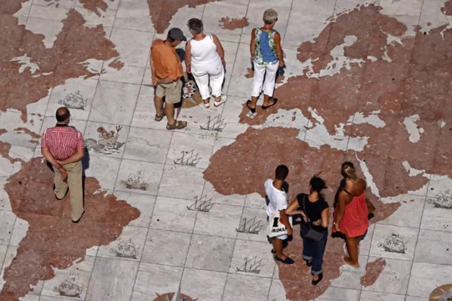 People walk over a world map in Lisbon. (Jose Manuel Ribeiro/courtesy Reuters)