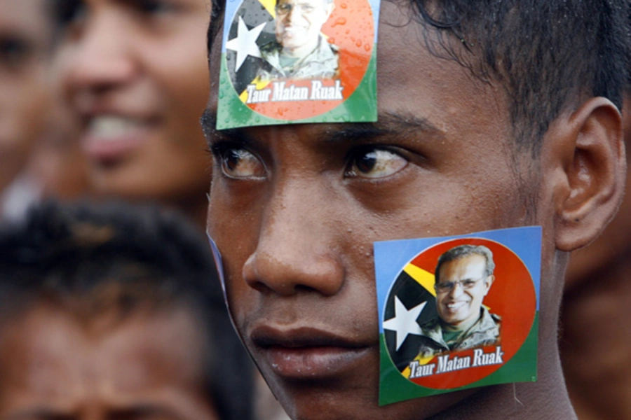 A youth pastes stickers of Timor-Leste's presidential candidate and former military commander Taur Matan Ruak on his face during a campaign rally in Dili March 10, 2012.