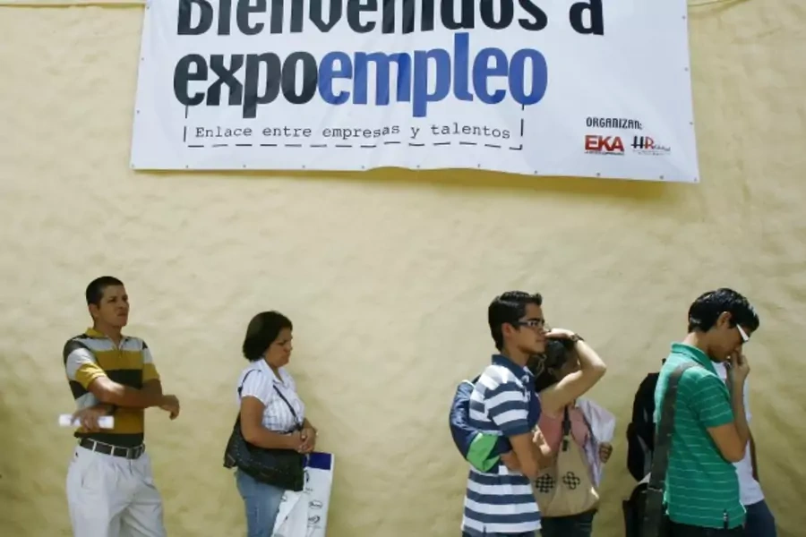 Job seekers join a line of hundreds of people at a job fair in Heredia