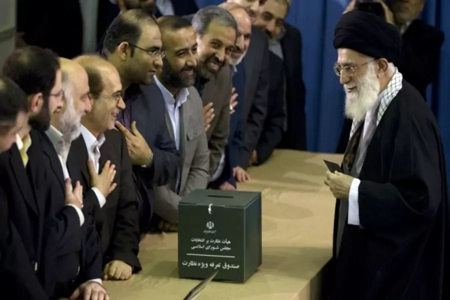 Iran's Supreme Leader Ayatollah Khamenei greets election officials as he prepares to cast his ballot in the parliamentary election in Tehran on March 2, 2012 (Courtesy Reuters/Caren Firouz).