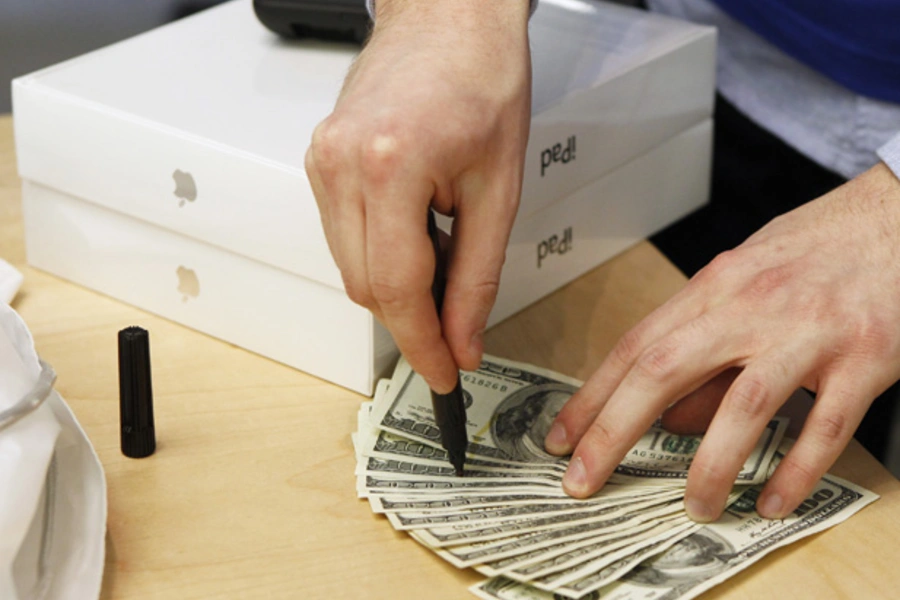 An Apple store employee checks cash for counterfeit bills after a customer purchased a pair of Apple iPad 2 tablets (Lucas Jackson/Courtesy Reuters).