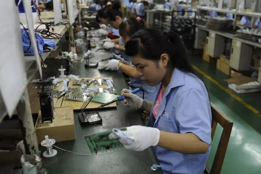 An employee works on circuit boards at an electronic component factory in Hefei,China (Stringer/Courtesy Reuters).
