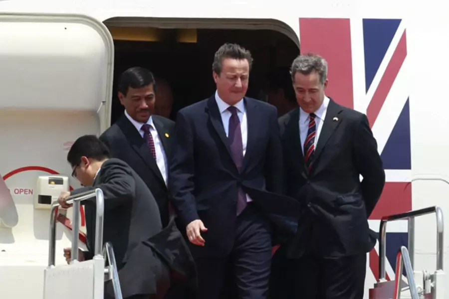 British prime minister David Cameron walks beside British Ambassador to Indonesia Mark Canning upon his arrival in Jakarta, April 11, 2012.