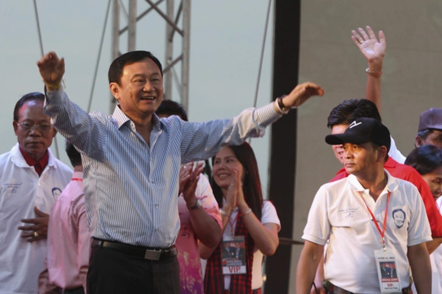 Former Thai prime minister, Thaksin Shinawatra (front L), welcomes his supporters during a ceremony in Siem Reap province, Cambodia, April 14, 2012.