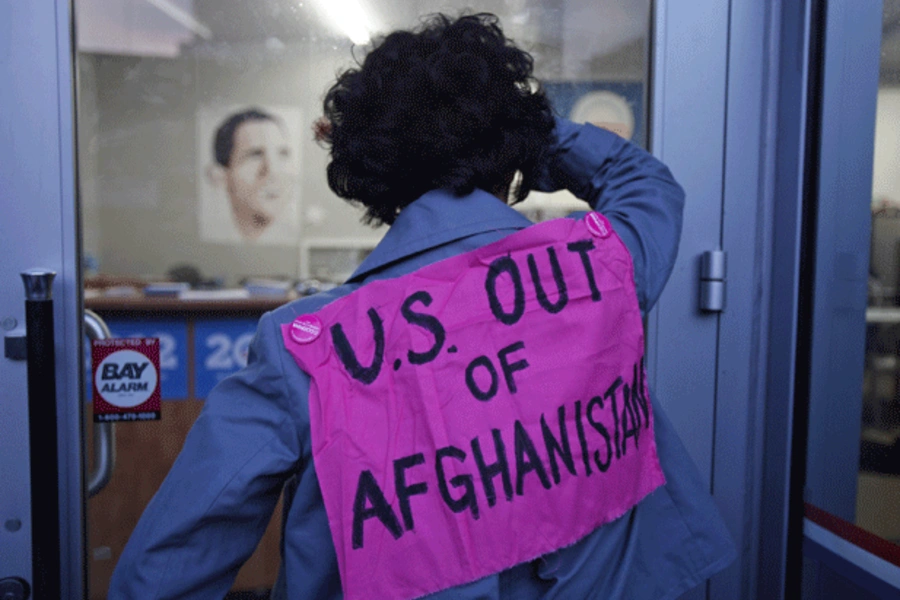 A protester affiliated with the anti-war group Code Pink looks into U.S. President Barack Obama's campaign headquarters. (Stephen Lam/courtesy Reuters)
