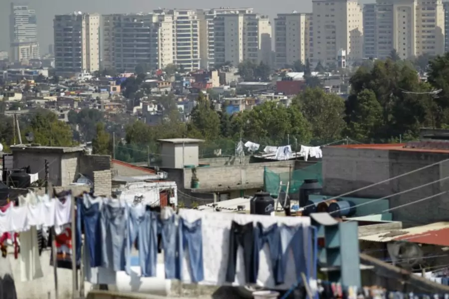 Apartment buildings stand behind a low-income neighborhood in Mexico City