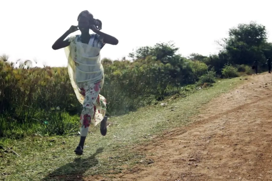 A woman runs from an air strike by the Sudanese air force in Rubkona, South Sudan (Courtesy Reuters/Goran Tomasevic).