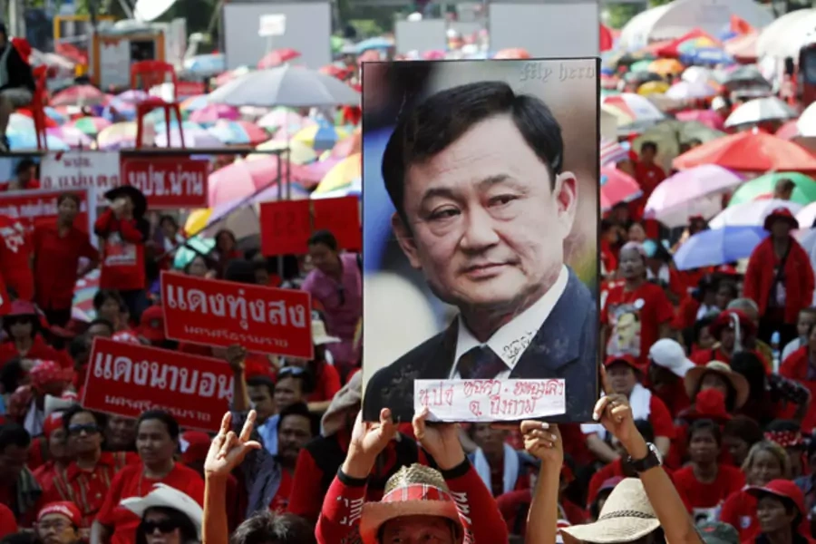 Red shirt protesters hold a picture of former prime minister Thaksin Shinawatra at a gathering to mark the second anniversary of a government crackdown on red shirt protestors in Bangkok May 19, 2012.