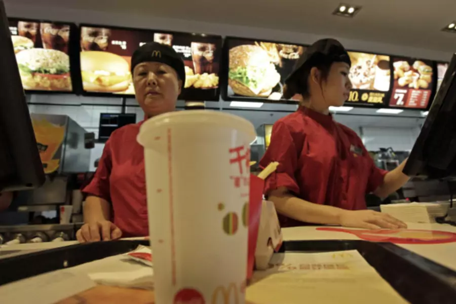 Employees at a McDonald's Restaurant in Beijing serve food to customers in October 2011 (Stringer/Courtesy Reuters).