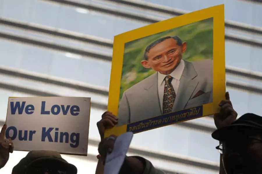 A protester holds up a portrait of Thailand's King Bhumibol during a rally in front of the U.S. embassy in Bangkok December 16, 2011.