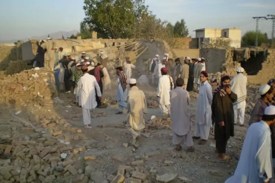 Tribesmen gather at a damaged house struck by a drone missile in northern Waziristan (Stringer Pakistan/Courtesy Reuters).