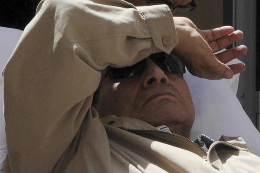 Former Egyptian President Hosni Mubarak is wheeled out of the courtroom in Cairo
